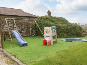 a yard with two slides and a playground at Gwel Eryri in Gaerwen