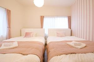 two beds sitting next to each other in a bedroom at Primehome Ninomiya in Fukiaichō
