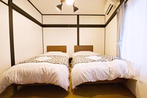 two beds sitting next to each other in a bedroom at Primehome Ninomiya in Fukiaichō