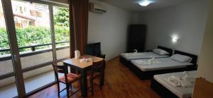 une chambre avec deux lits, une table et une fenêtre dans l'établissement LaRaMi Studio, à Sveti Vlas 5 autres photos