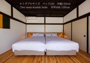 Postel nebo postele na pokoji v ubytování 萩・城下町の宿　椿庵