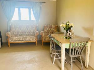 a living room with a table and chairs and a couch at Doornboom Farm Self Service in Heidelberg