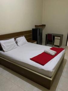 um quarto com uma cama com um cobertor vermelho em Homestay at Candi Gebang by ecommerceloka em Sleman