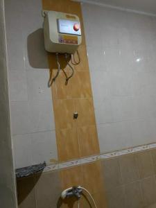 un dispenser di sapone sul muro di un bagno di Homestay at Candi Gebang by ecommerceloka a Sleman