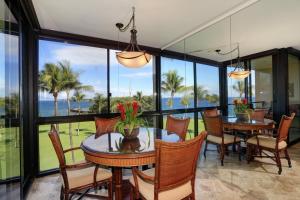 comedor con mesas y sillas y vistas al océano en Kihei Surfside, #511 condo, en Wailea