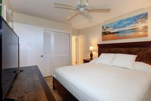1 dormitorio con 1 cama y ventilador de techo en Kihei Surfside, #511 condo, en Wailea