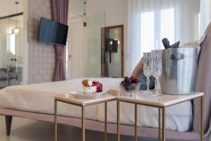 a room with a bed with a table with a cake and glasses at Maiolica Rooms in Ragusa