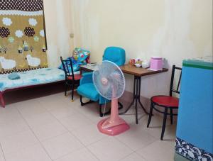 a room with a table and a pink fan at NP guesthouse in Trat