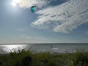 une personne pratiquant le kitesurf dans l'eau sur la plage dans l'établissement Beachhouse Langeland, à Tranekær