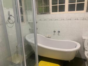 a bathroom with a bath tub and a shower at Maisha@Toti in Amanzimtoti