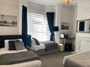a bedroom with two beds and a window at Aaron in Southport
