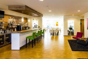 a restaurant with a bar with green chairs at Hotel Eyberg in Dahn