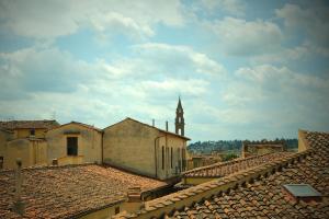 una vista de los tejados de los edificios con una torre de reloj en Mamo Florence - Parione Roof Terrace, en Florencia
