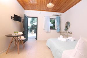 sypialnia z łóżkiem, stołem i oknem w obiekcie Andromache's w mieście Gastouri