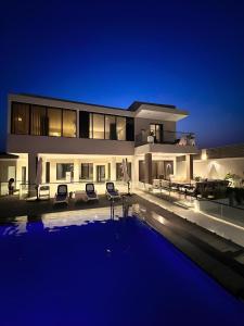 a large house with a swimming pool at night at Al Qand Chalet For Families Only in Half Moon Bay