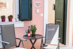 stół i dwa krzesła przed drzwiami w obiekcie Andromache's w mieście Gastouri