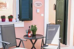 stół i dwa krzesła oraz stół i drzwi w obiekcie Andromache's w mieście Gastouri