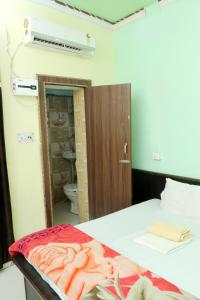 a room with a bed and a bathroom with a mirror at Creeper Hotel And Restaurant in Rohtak