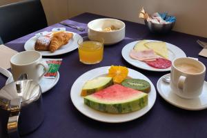 uma mesa com pratos de comida e chávenas de café em Onix Liceo em Barcelona