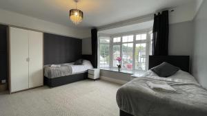 - une chambre avec 2 lits et une fenêtre dans l'établissement Luxurious Kitchen Lrg Bedrooms Holiday FreeParking, à Luton