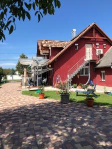 una casa roja con macetas delante de ella en Napfény Ház Sonnenschein Haus, en Balatonőszöd