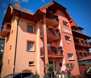 a large orange building with flowers on the balconies at Willa Mona in Międzywodzie