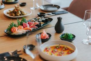 a table with plates of sushi and a bowl of soup at Royal Apollonia by Louis Hotels in Limassol