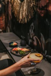 a person holding a plate of food on a table at Royal Apollonia by Louis Hotels in Limassol
