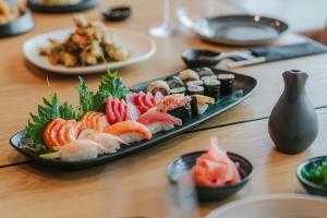 a table with a plate of sushi and other food at Royal Apollonia by Louis Hotels in Limassol