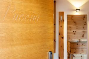 a wooden door with the word nooni written on it at Villa Solinda App Puccini in Selva di Val Gardena