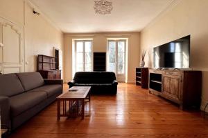 uma sala de estar com um sofá e uma mesa em Appartement en coeur de village em Bourg-sur-Gironde