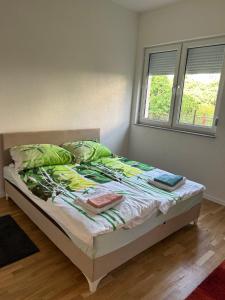 - un lit avec des draps et des oreillers verts dans une chambre dans l'établissement Vila Kasindol, à Sarajevo