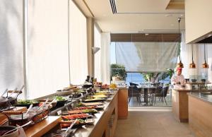 a buffet line with food on it in a kitchen at Royal Apollonia by Louis Hotels in Limassol