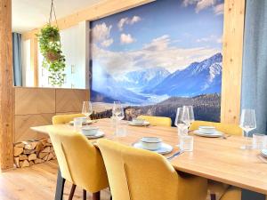 a dining room with a table and chairs with a mountain mural at Best Butler Active Alpin Hund Küche Parken in Füssen