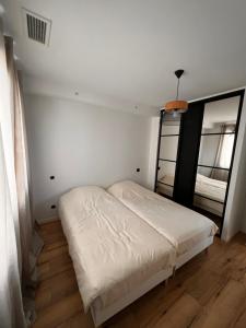 um quarto com uma cama branca e um espelho em House Prestige em Juvignac