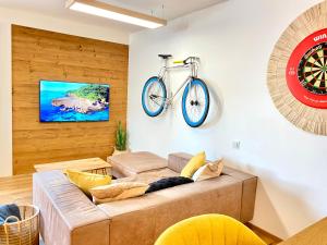 a living room with a couch and a bike hanging on the wall at Best Butler Active Alpin Hund Küche Parken in Füssen