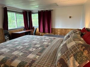 a bedroom with a large bed with red curtains at Uncle Nicolai's Inn B&B in Copper Center