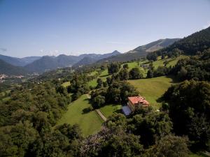 eine Luftansicht eines Hauses auf einem grünen Feld in der Unterkunft Hotel Villa Simplicitas in San Fedele Intelvi