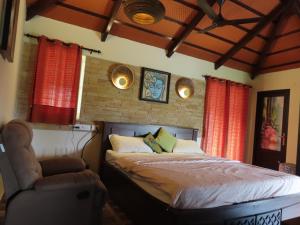 a bedroom with a bed and a chair at Misty Hills Retreat in Coimbatore