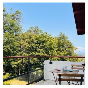 una mesa en un balcón con vistas a los árboles en Home Sweet Home, en Gex