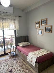 a bedroom with a bed and a table and a window at Panoramic apartment in Shkodër