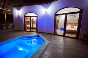 a large swimming pool in a room with a bedroom at Emerald Dreams Boutique Hotel in Michamvi