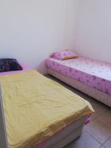 two beds in a room with yellow sheets at House with garden in Bodrum in Bodrum City