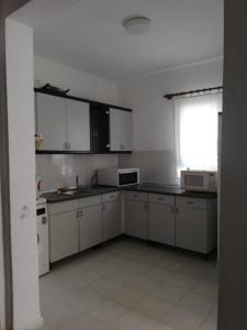 an empty kitchen with white cabinets and appliances at House with garden in Bodrum in Bodrum City