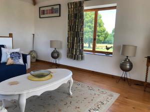 a living room with a white coffee table and a window at Chez Goret Gites - Gite Skippy Couples only 