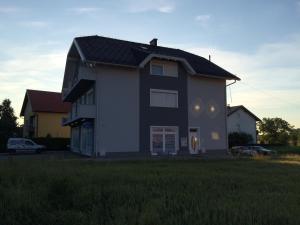 a house with a black roof on a grass field at Guest House Šeperić in Jastrebarsko