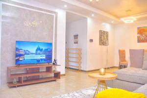 a living room with a large flat screen tv at Chic 2-Bedroom Haven in Kilimani in Nairobi