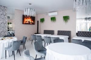 a dining room with tables and chairs and a fireplace at Hostel VinoGrad in Haysyn