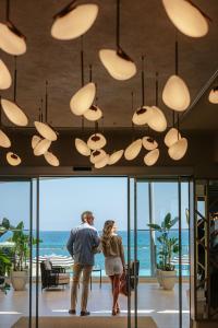 Ein Mann und eine Frau stehen in einem Zimmer mit Licht in der Unterkunft Royal Apollonia by Louis Hotels in Limassol