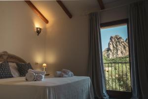 Schlafzimmer mit einem Bett und Bergblick in der Unterkunft Borgo Antico San Pantaleo in San Pantaleo